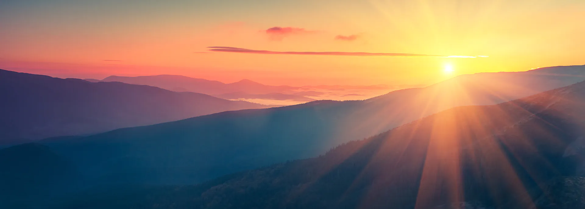 Panoramic view of colorful sunrise in mountains.