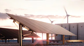 Solar panels and large energy machines with rotating wind turbines in the background