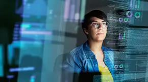 person behind transparent digital screens of charts and graphs