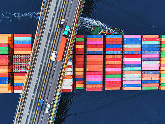 Cars on a bridge over container ship